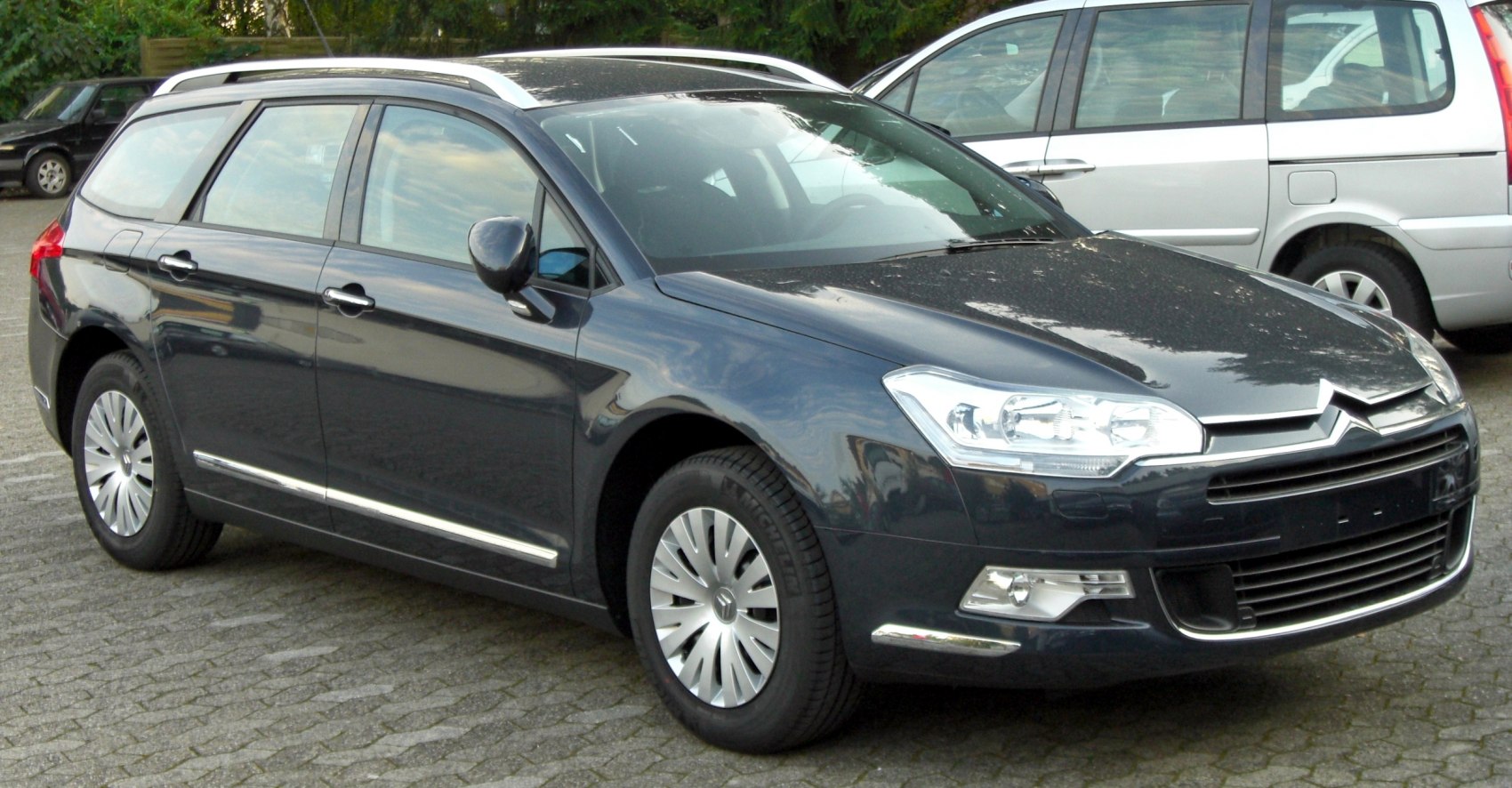 Front-side view of sleek station wagon with roof rails and alloy wheels