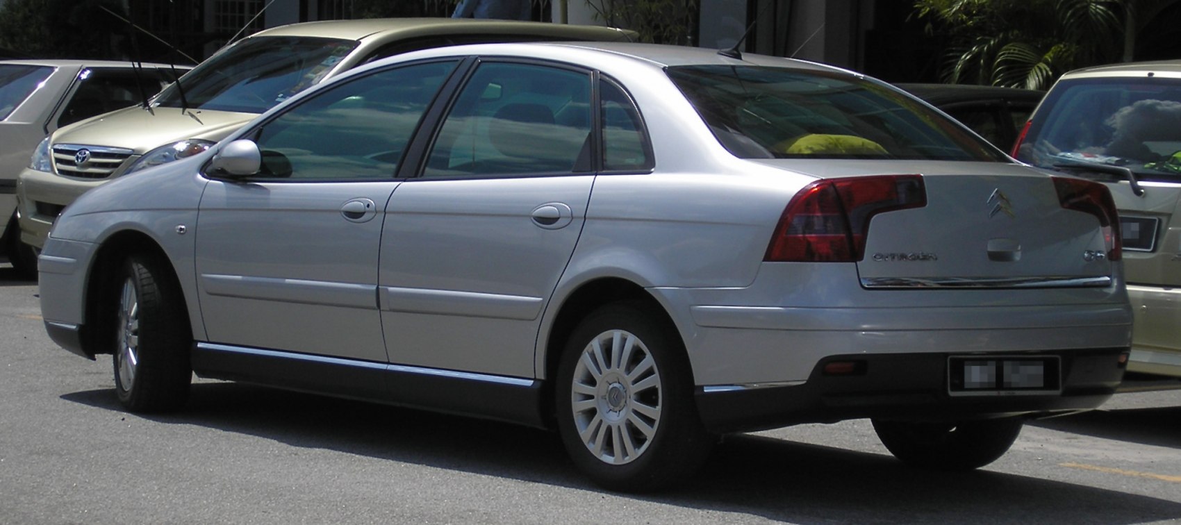 Rear side view of a silver sedan with distinct taillights and alloy wheels