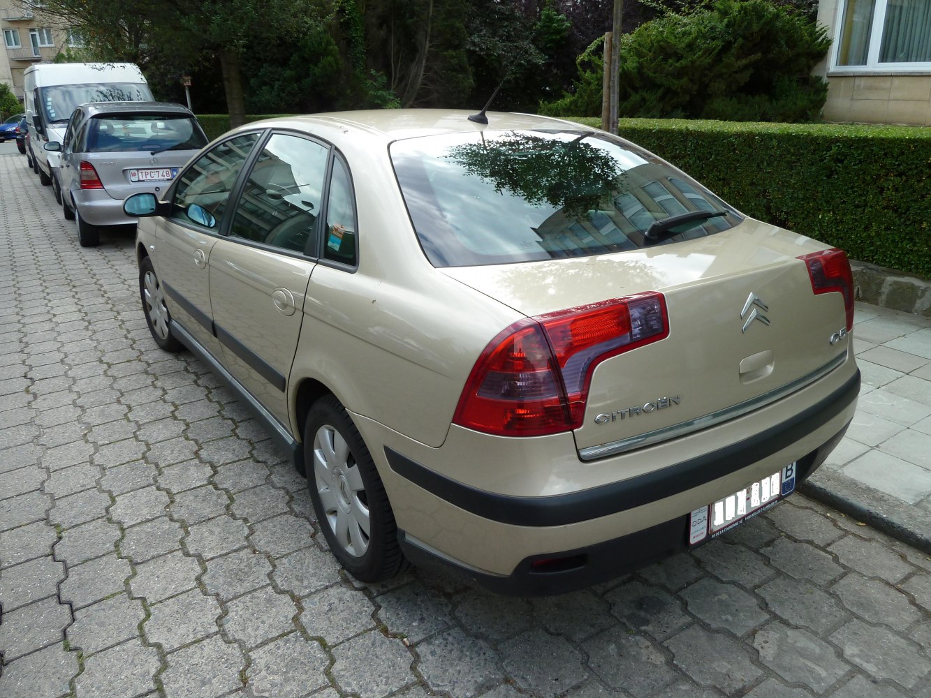 Rear beige sedan with L-shaped tail lights and rear windshield wiper