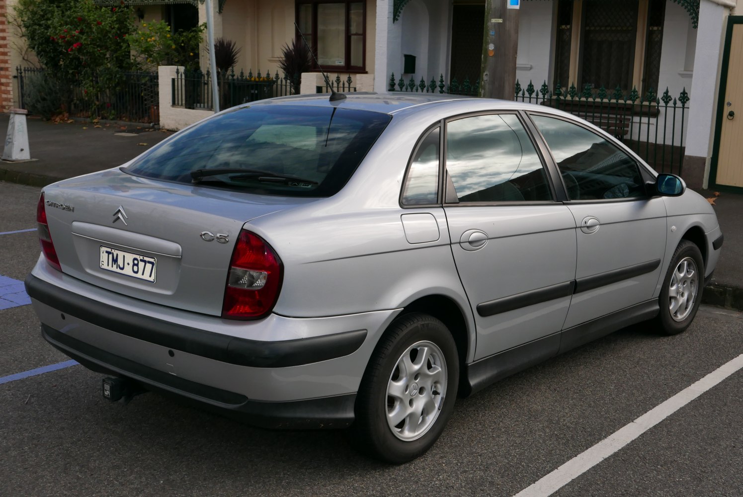 Silver sedan rear and side view with black trim and tow hitch