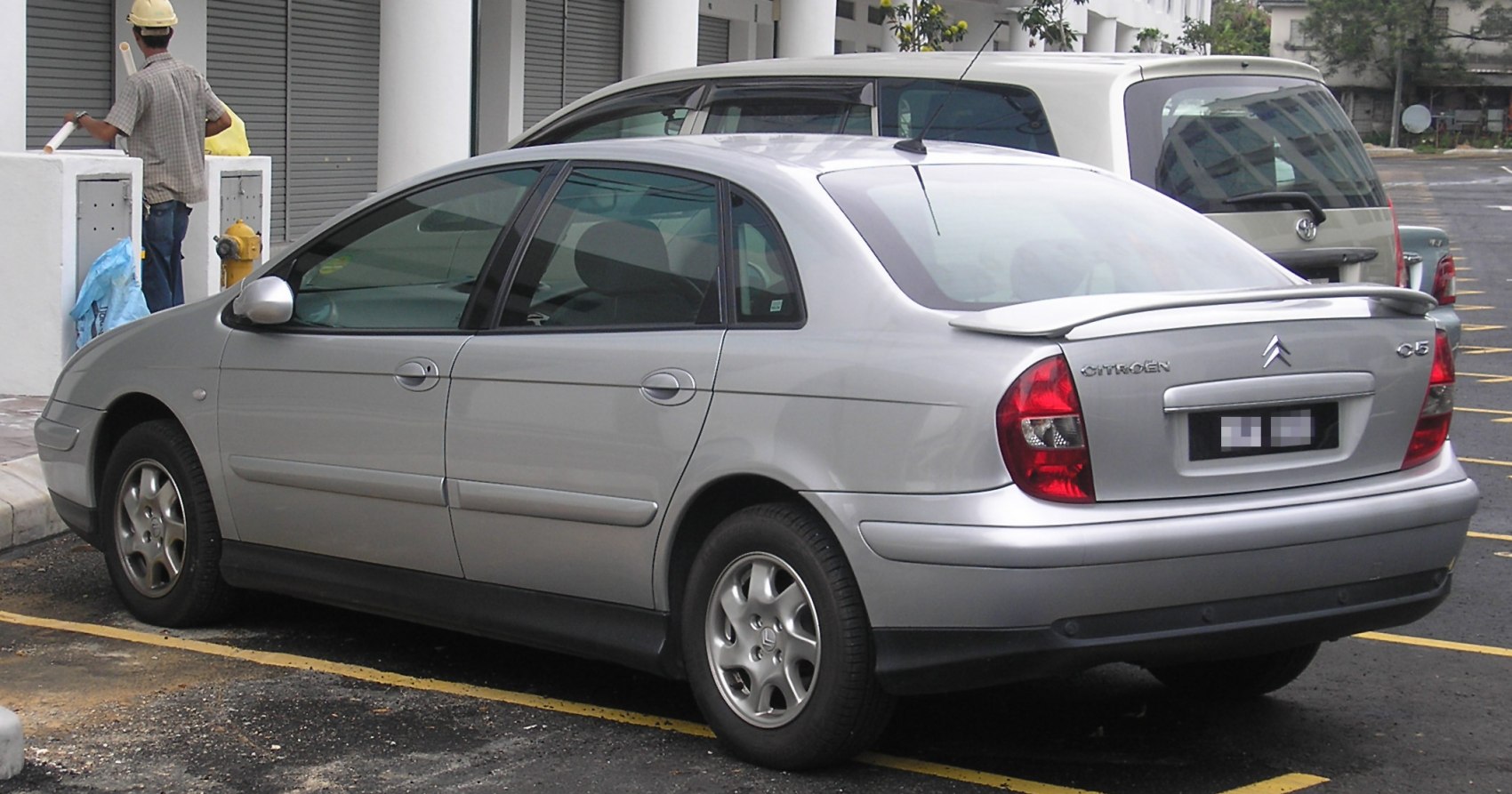 Silver four-door sedan with rear spoiler and alloy wheels.