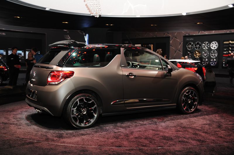 Compact convertible with retractable soft top and black alloy wheels in matte finish.