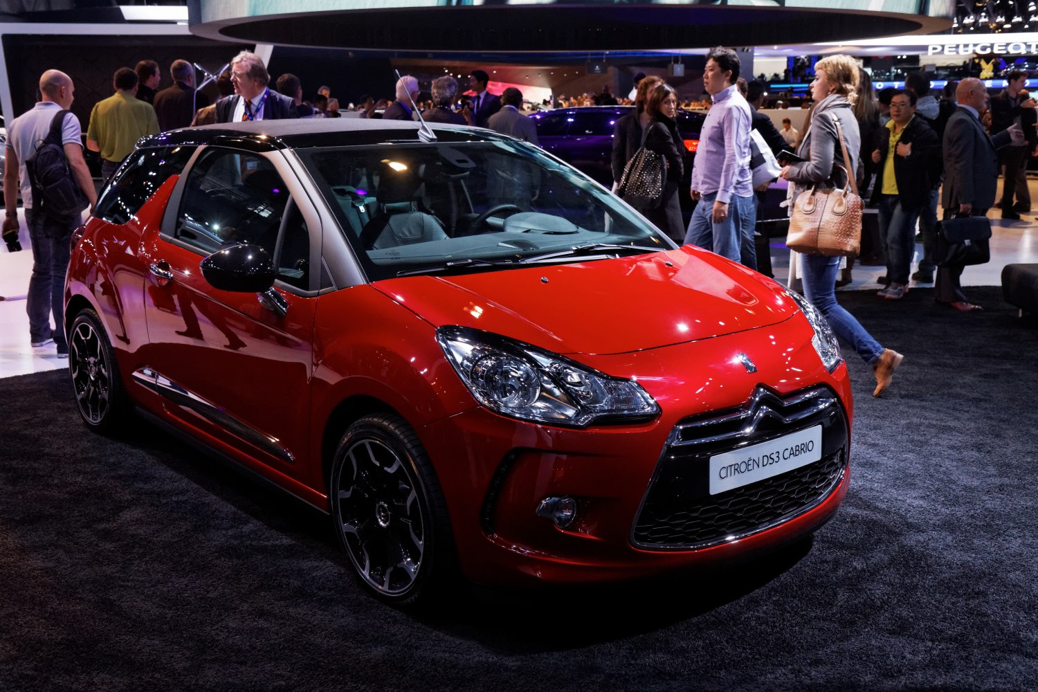 Compact red convertible with black roof and alloy wheels