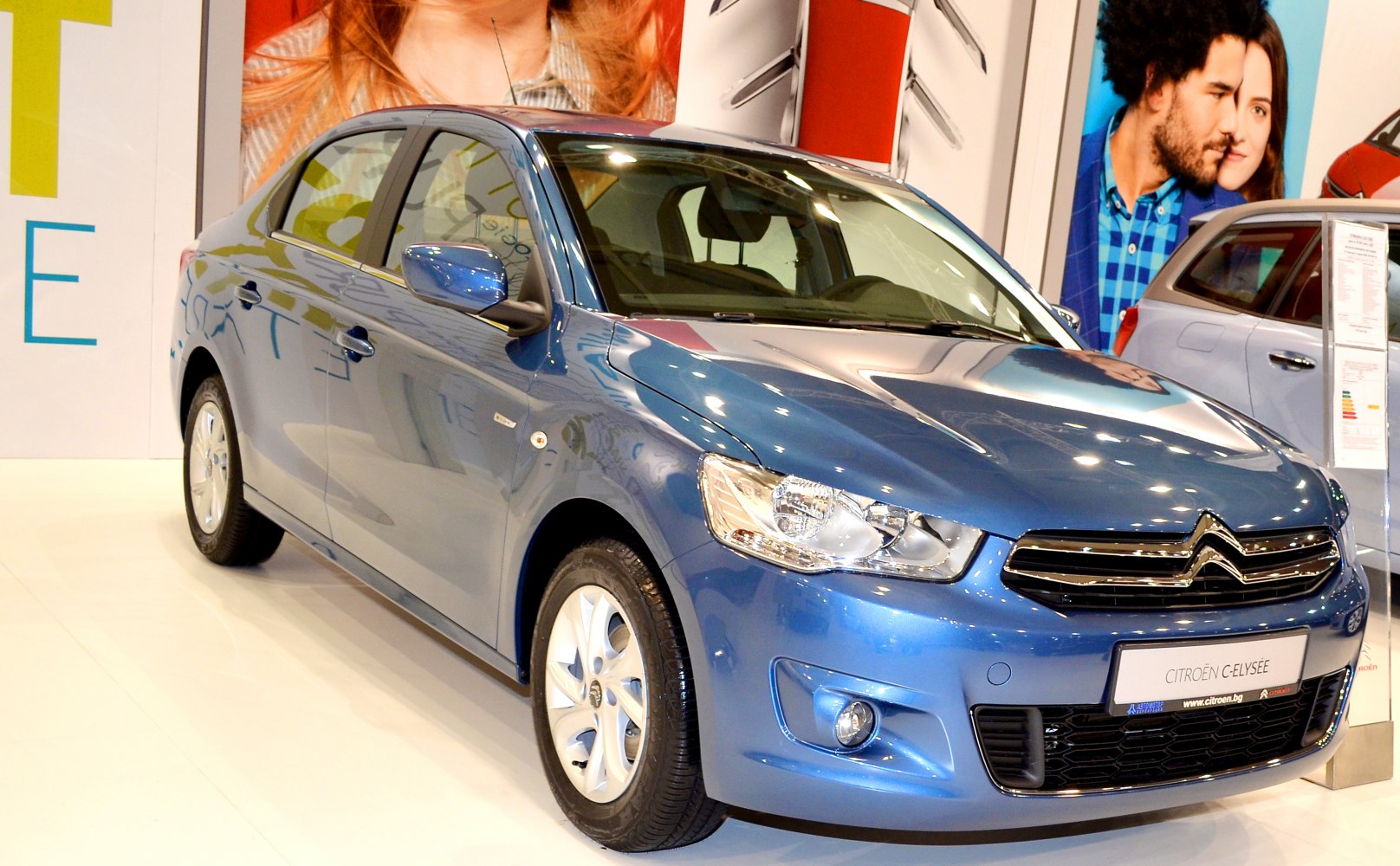 Front and side of a sedan with prominent headlights and grille