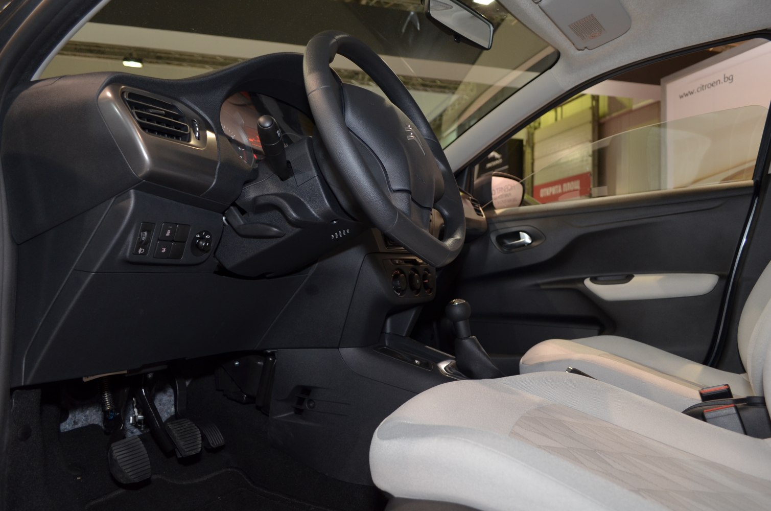 Manual transmission interior with steering, dashboard, pedals, and front seats