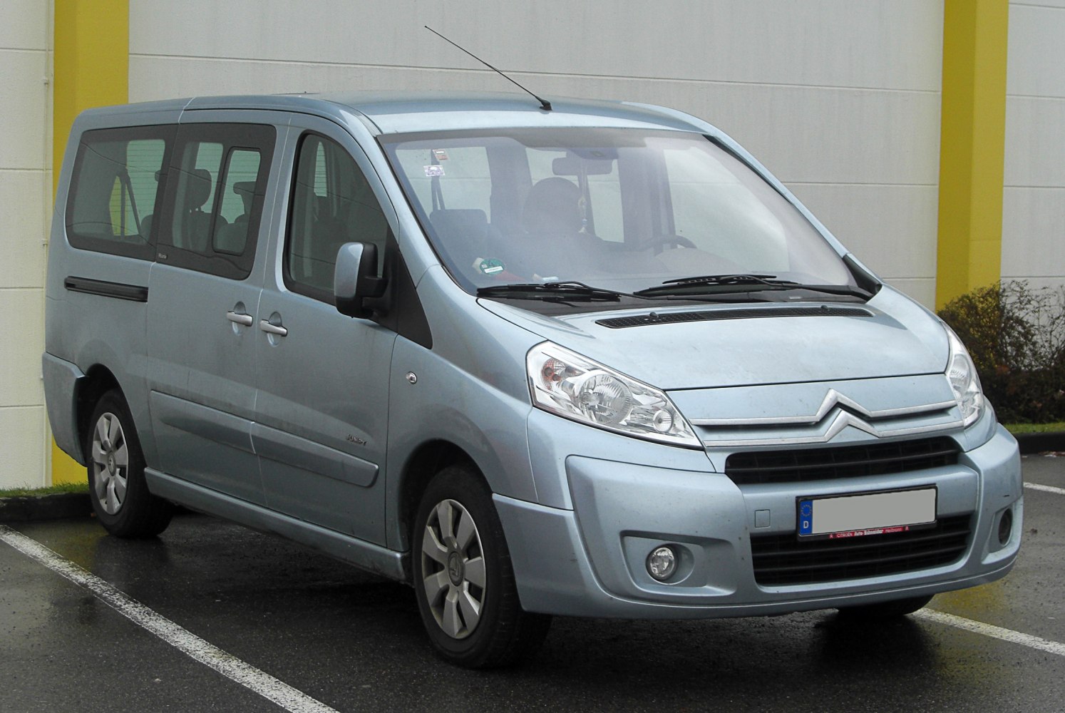 Front and side view of a multi-purpose van with large windows and sliding door