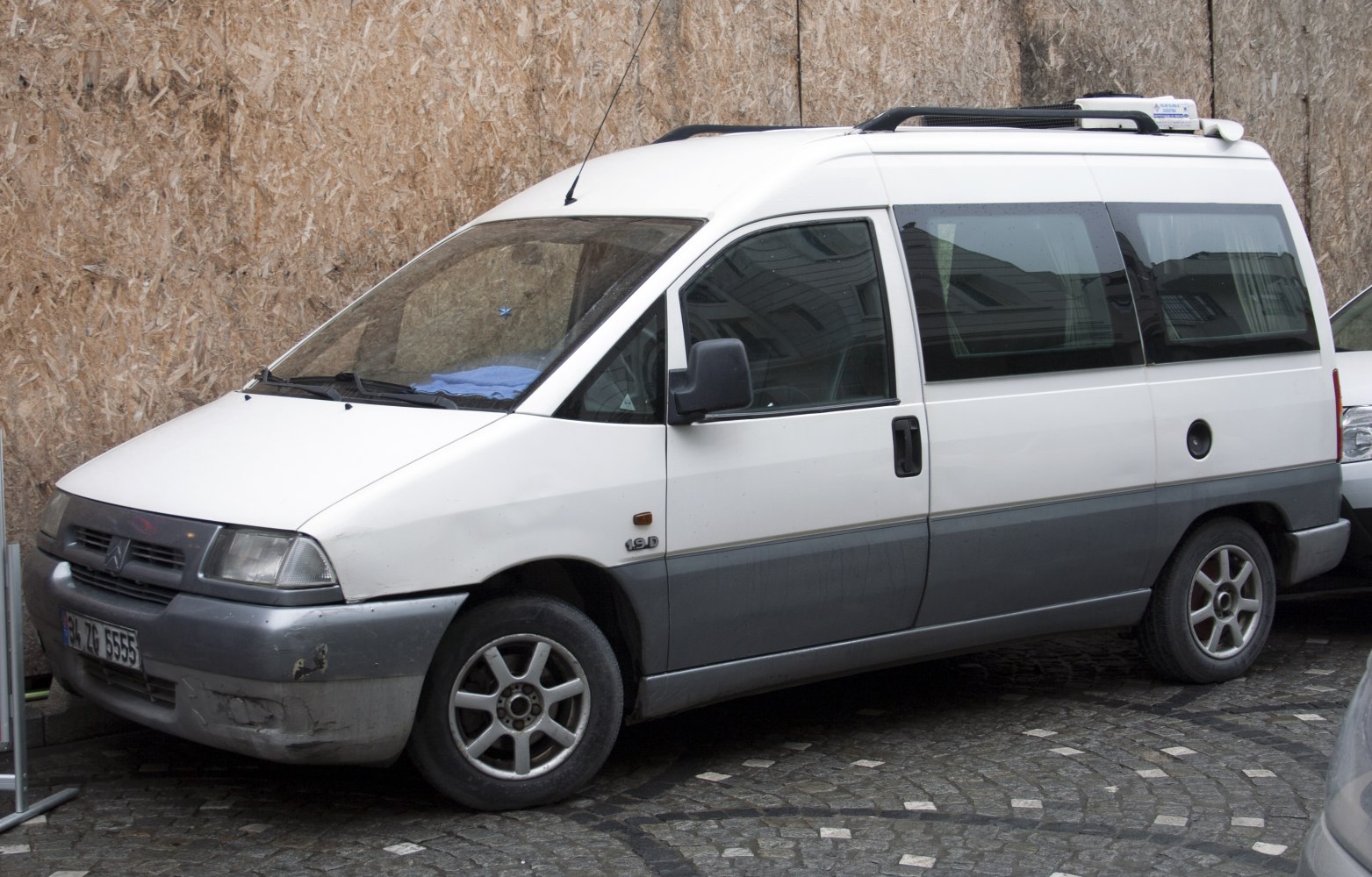 Side profile of a late 90s van with sliding door and roof rack