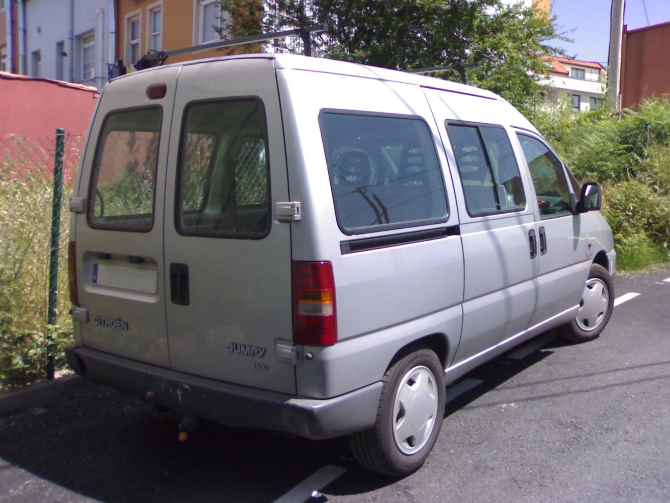 Rear side view of boxy cargo van with rear windows and sliding side door