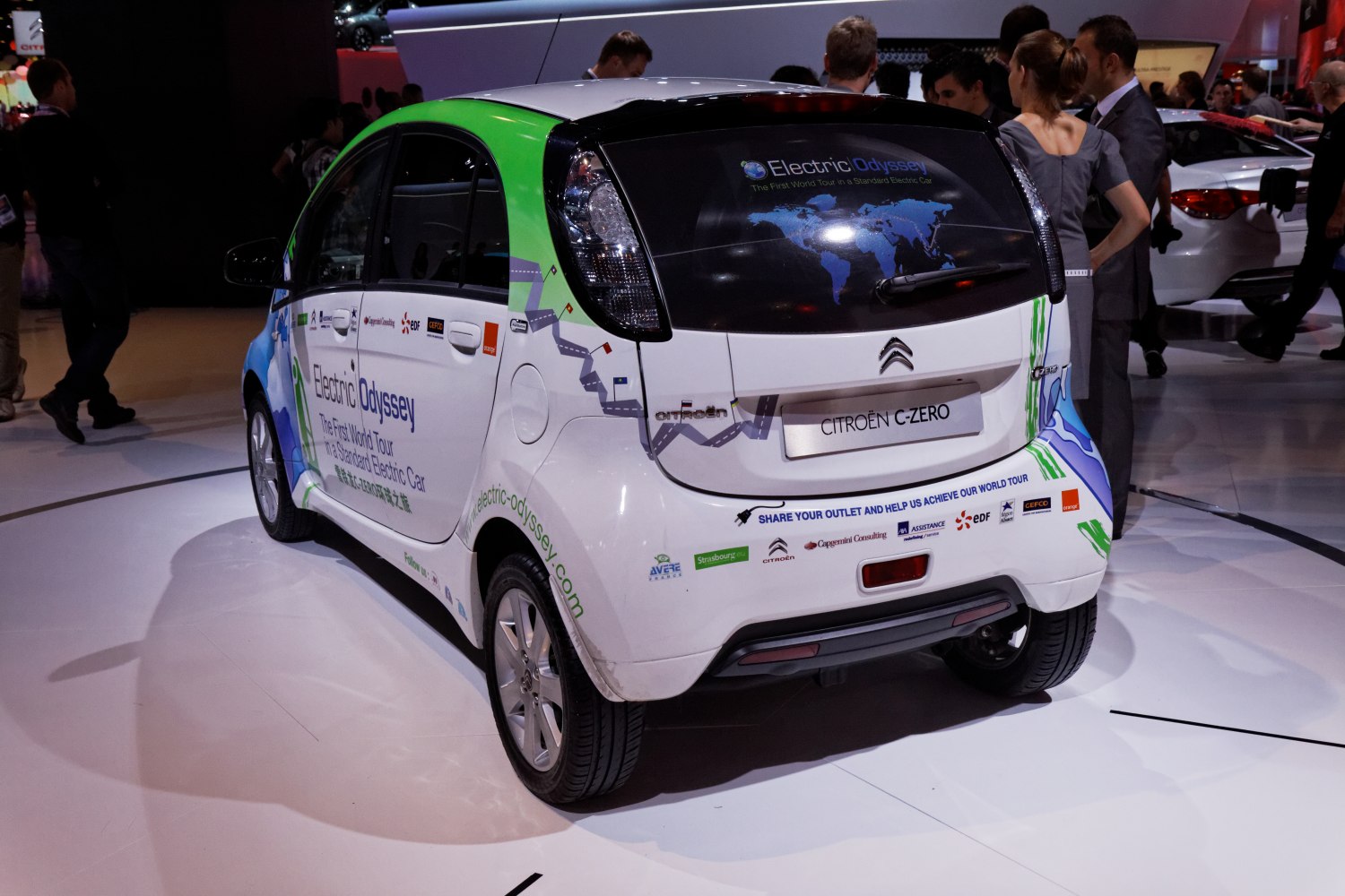 Rear view of small electric hatchback with eco promotional wrap.