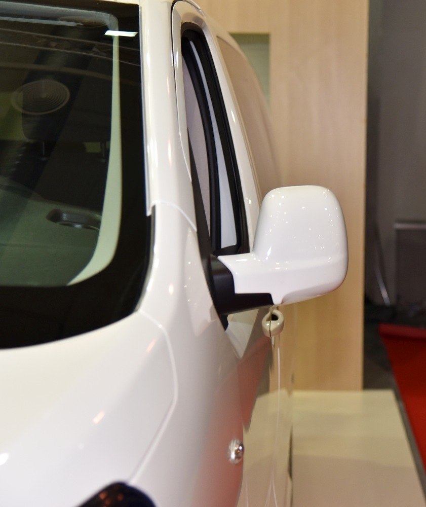 Close-up of white passenger van side mirror and window