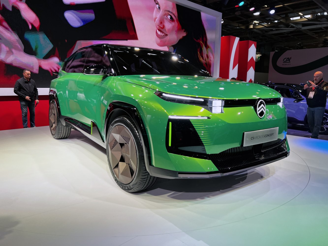 Futuristic green SUV with sharp LED headlights and geometric wheels