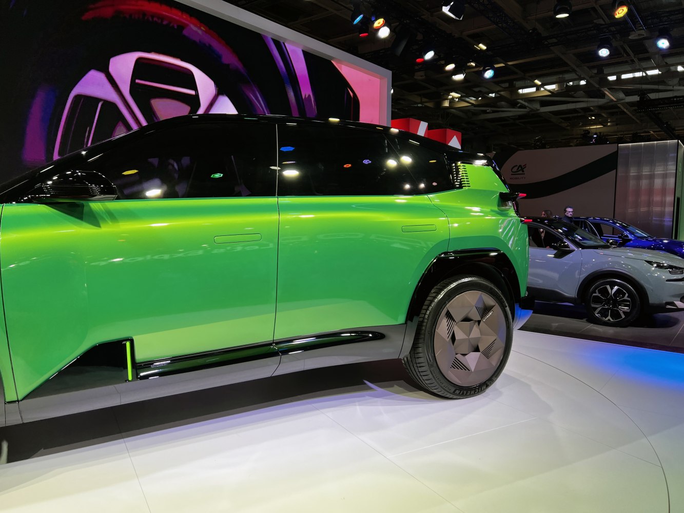 Sleek green SUV side view with futuristic wheels and flush door handles
