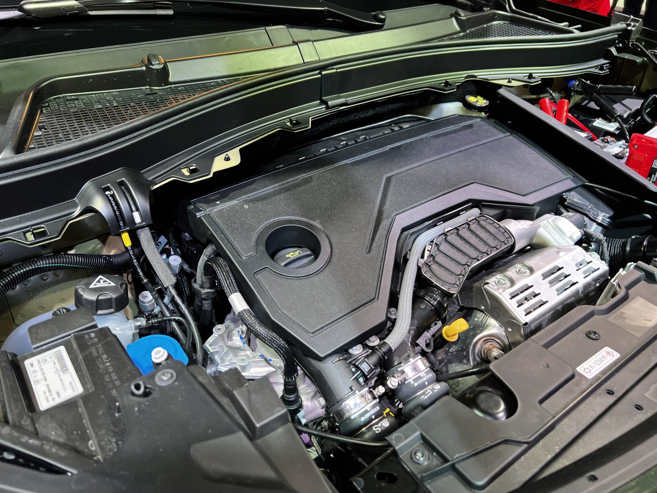 Close-up of engine cover and components under hood.
