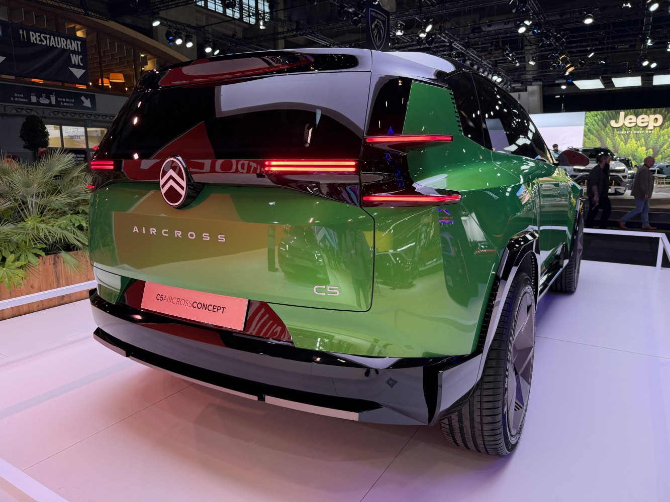 Futuristic rear design with LED light signature on green SUV.