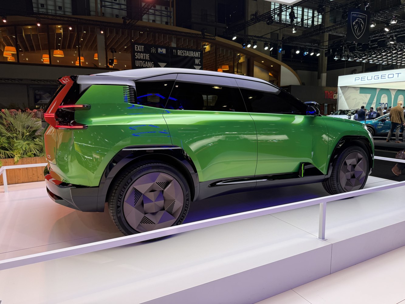 Side profile and futuristic geometric wheels of green SUV