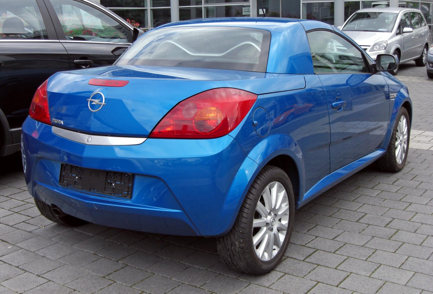 Rear view of a blue compact convertible with alloy wheels and distinctive taillights