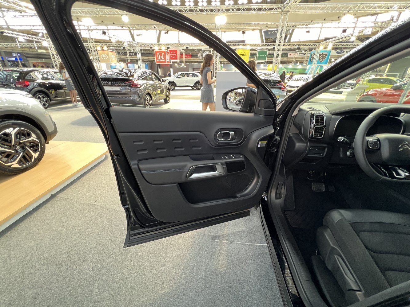 Black interior door panel with controls and dashboard layout.