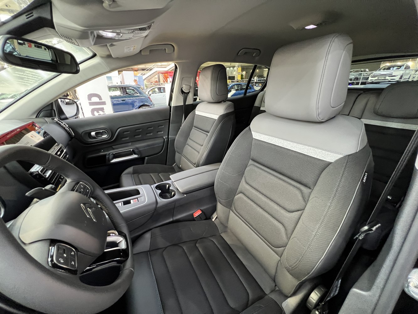 Ergonomic front seats and modern interior design with cup holders and steering wheel controls.