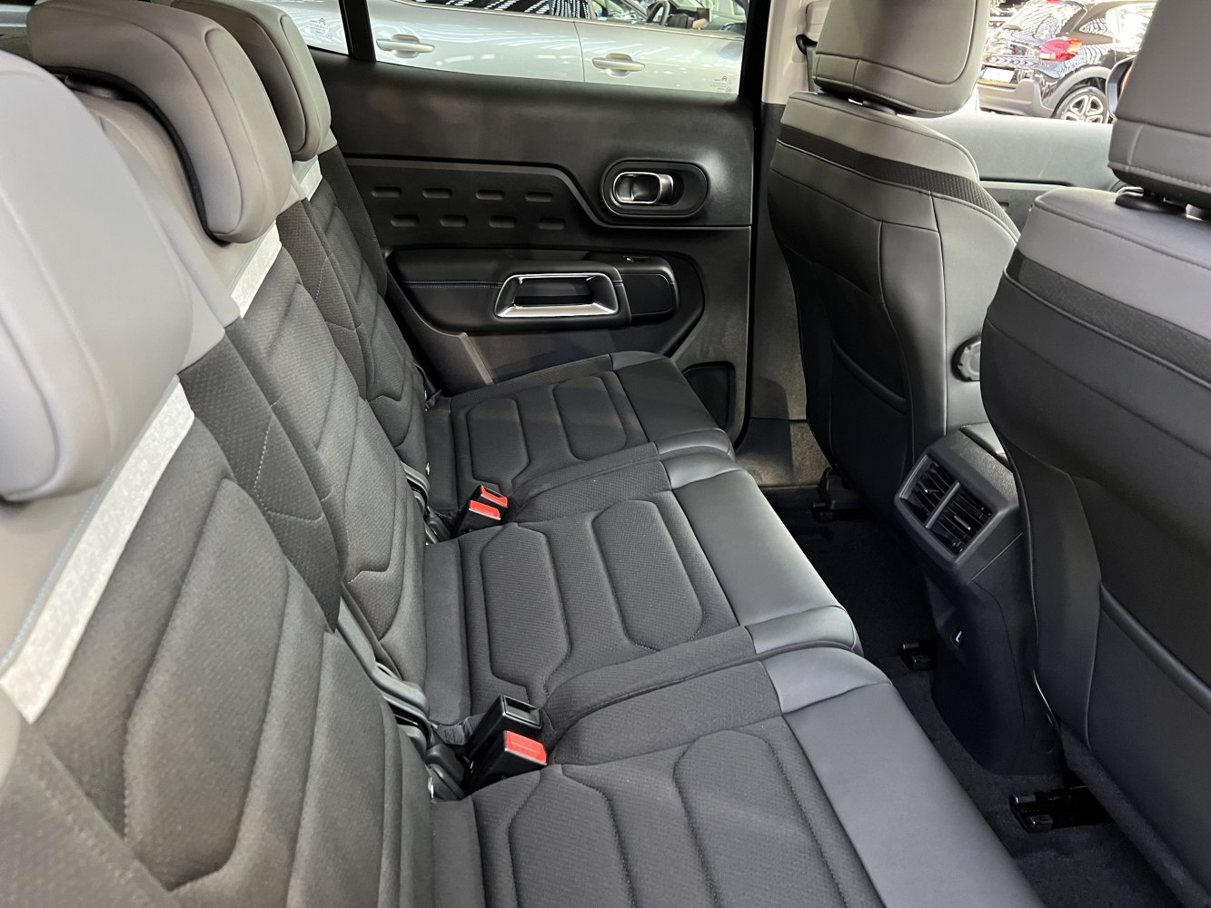 Rear seats with fabric and leather upholstery, featuring air vents and door panel details