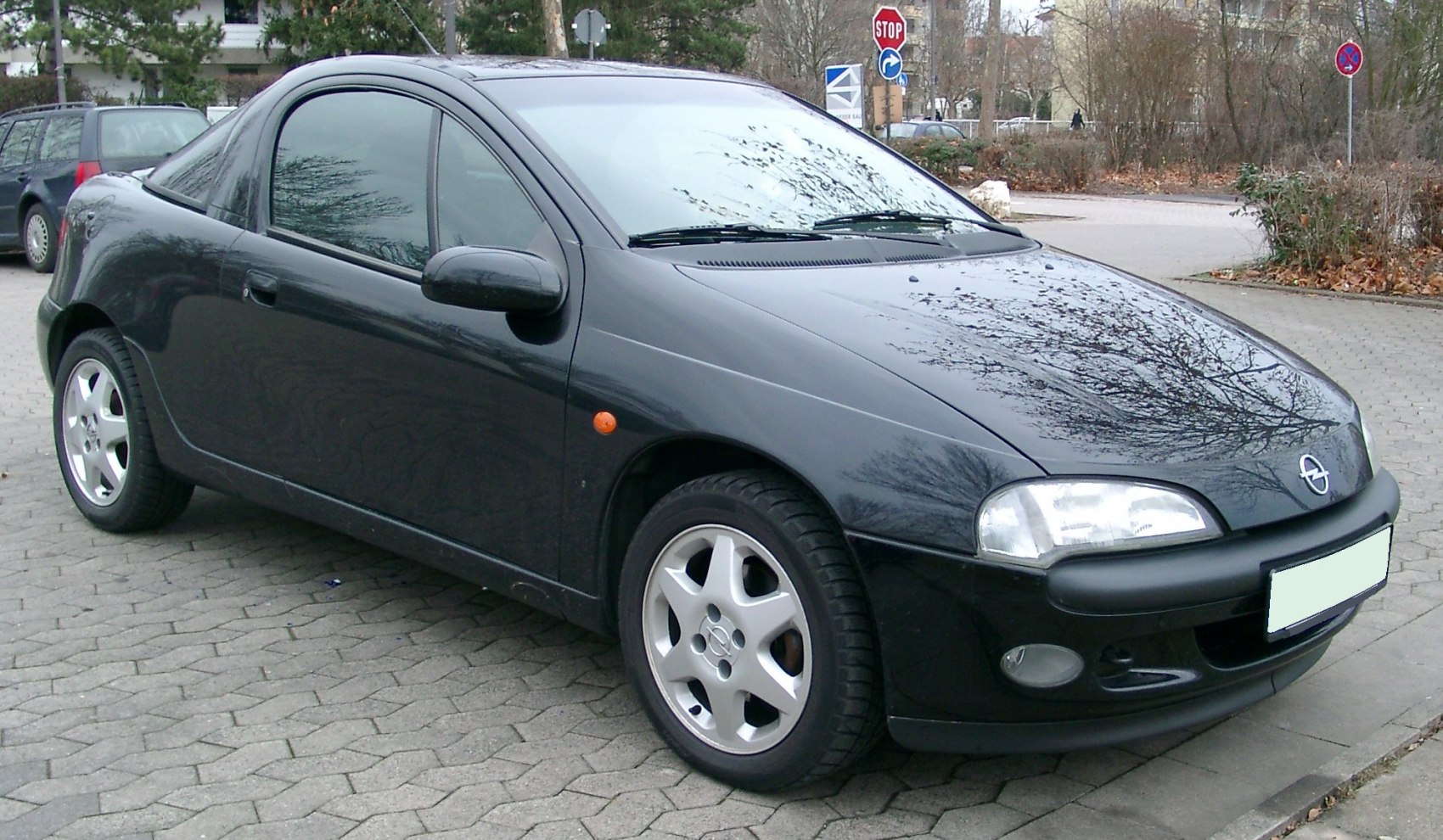 Compact coupe with black paint and alloy wheels, front side view