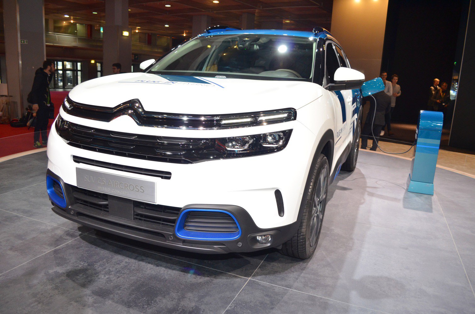 Front view of hybrid SUV at charging station