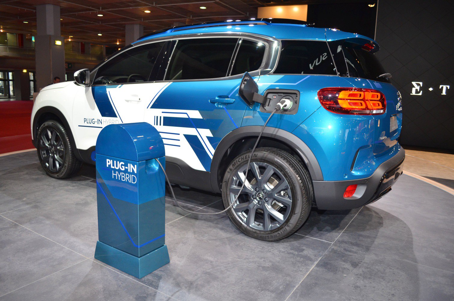 Plug-in hybrid SUV side view charging at station