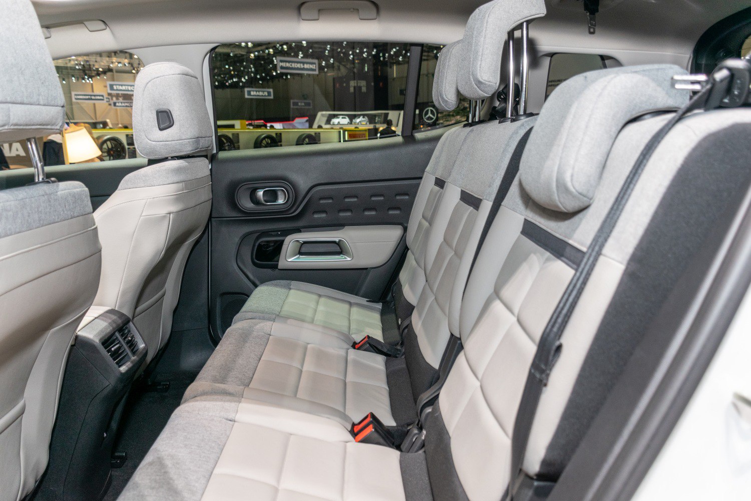 Rear seats with grey and beige upholstery, headrests, and ventilation vents
