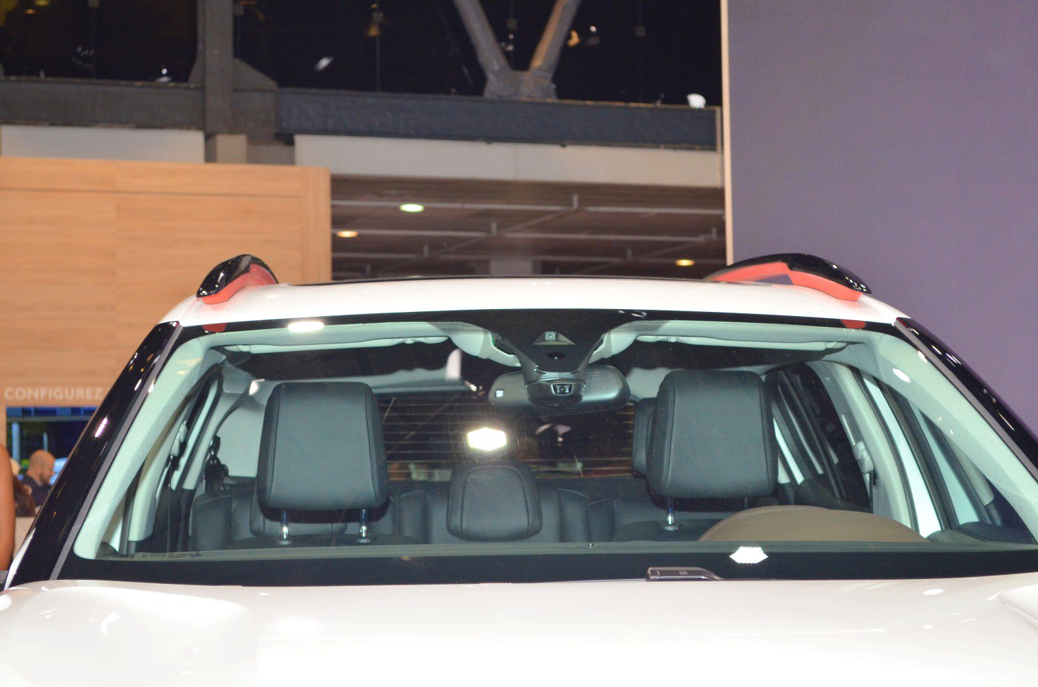 Front seats, headrests, dashboard camera, roof rails visible through windshield