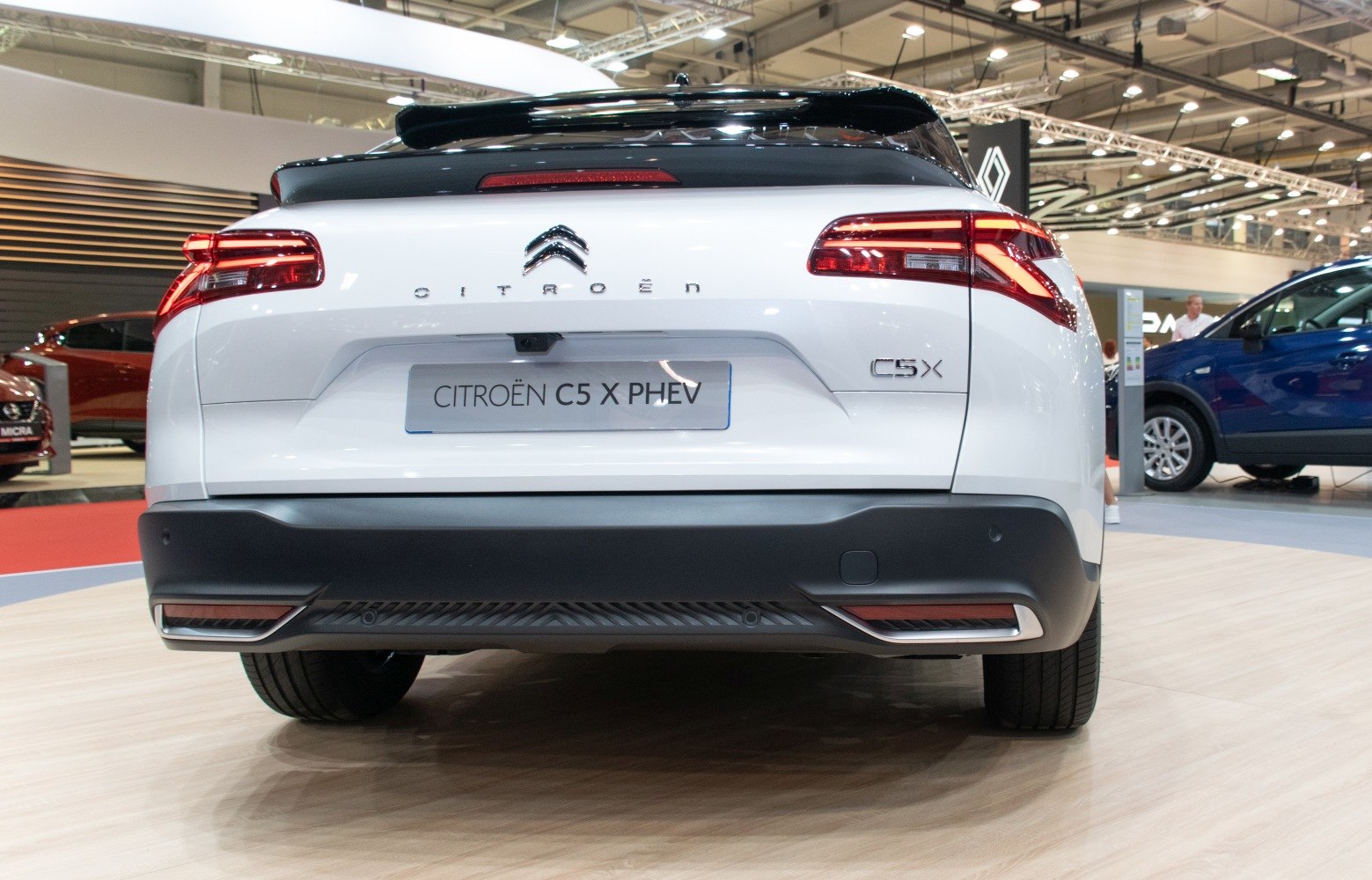 Modern car tail lights and rear design in a showroom setting