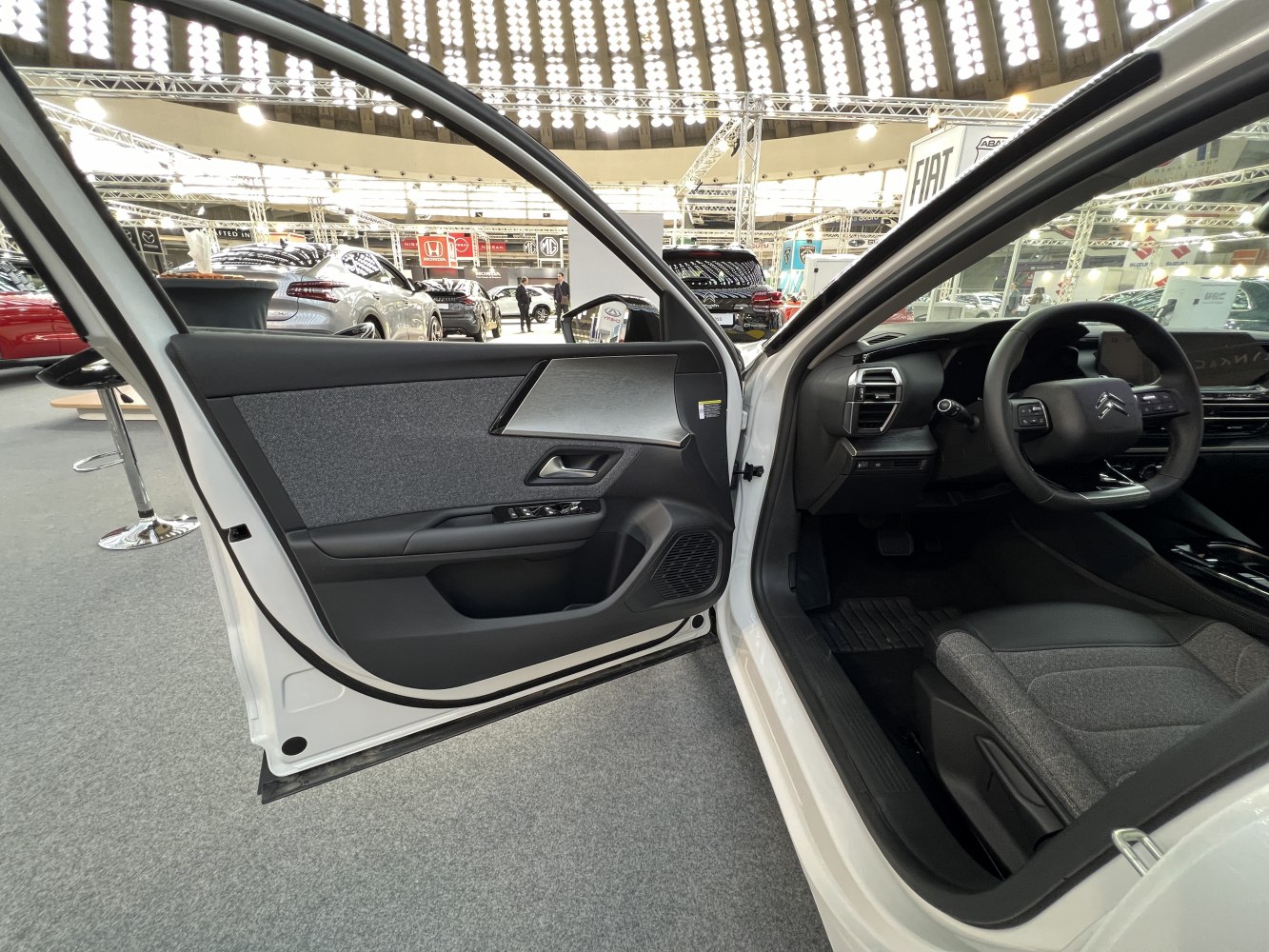 Open driver door panel with steering wheel and seat interior