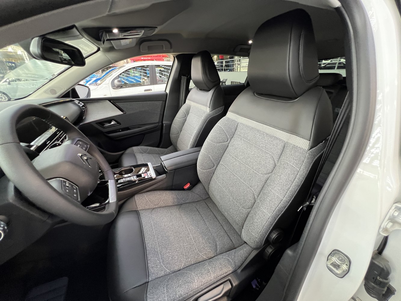 Front fabric and leather car seats with modern dashboard and steering wheel