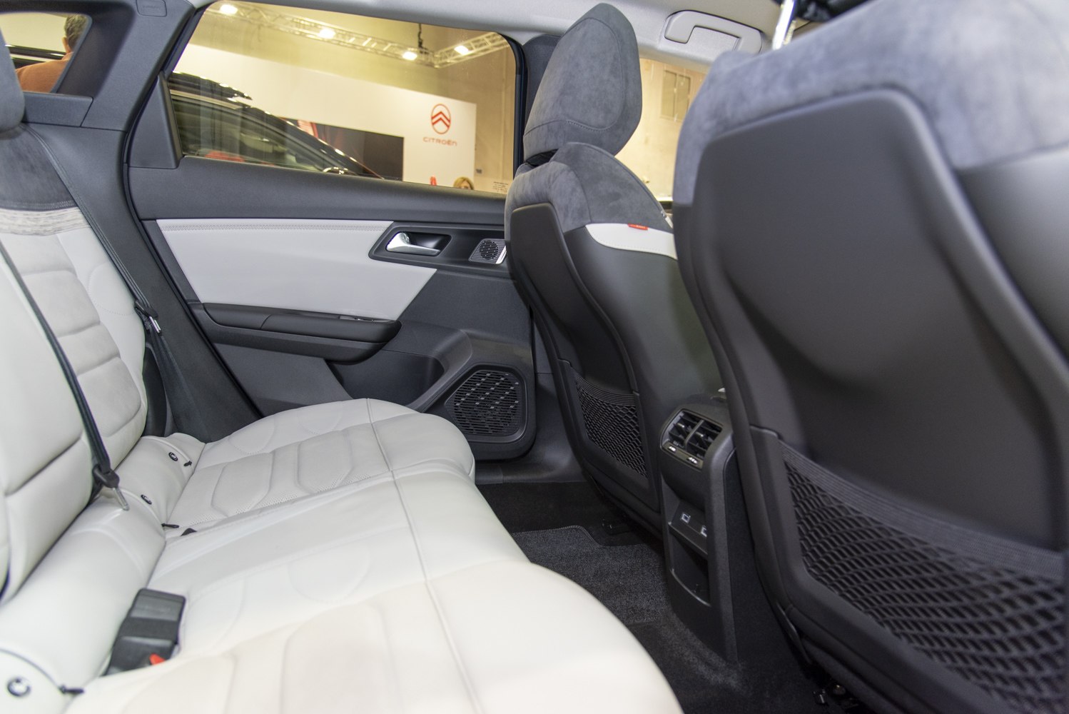 Rear interior with spacious white seats and rear air vents.