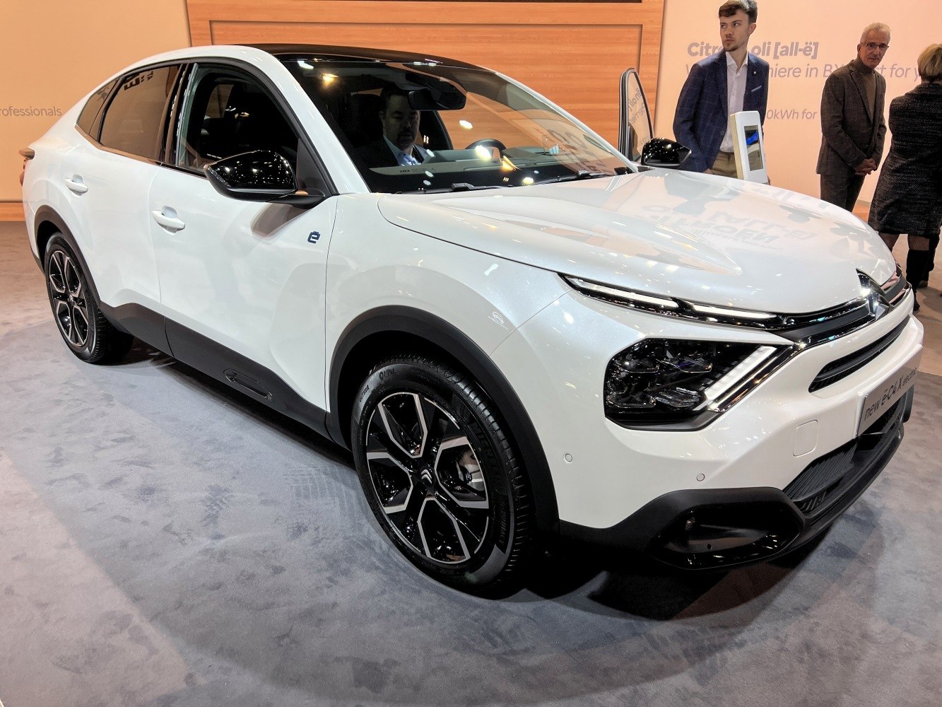 White electric compact sedan, LED headlights, sporty wheels
