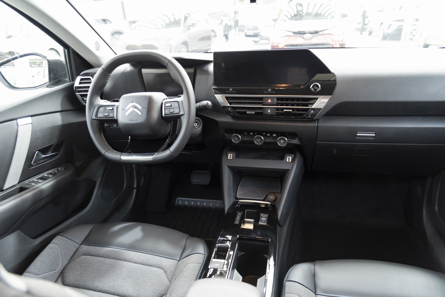 Steering wheel with controls and large digital touchscreen dashboard.