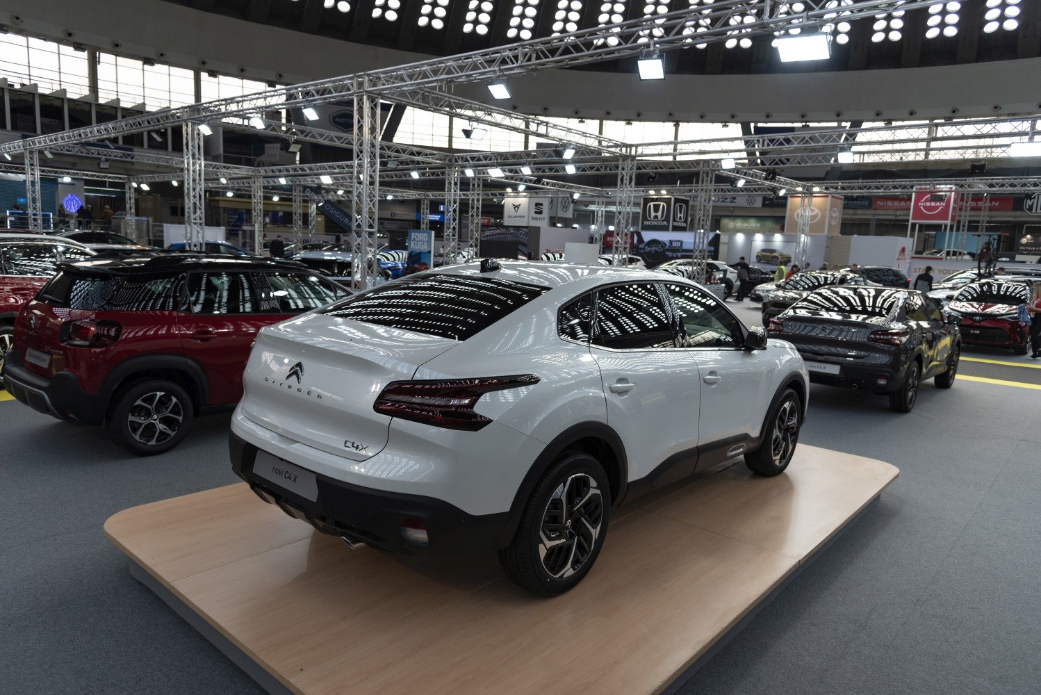 Rear and side profile of white 2023 sedan on platform
