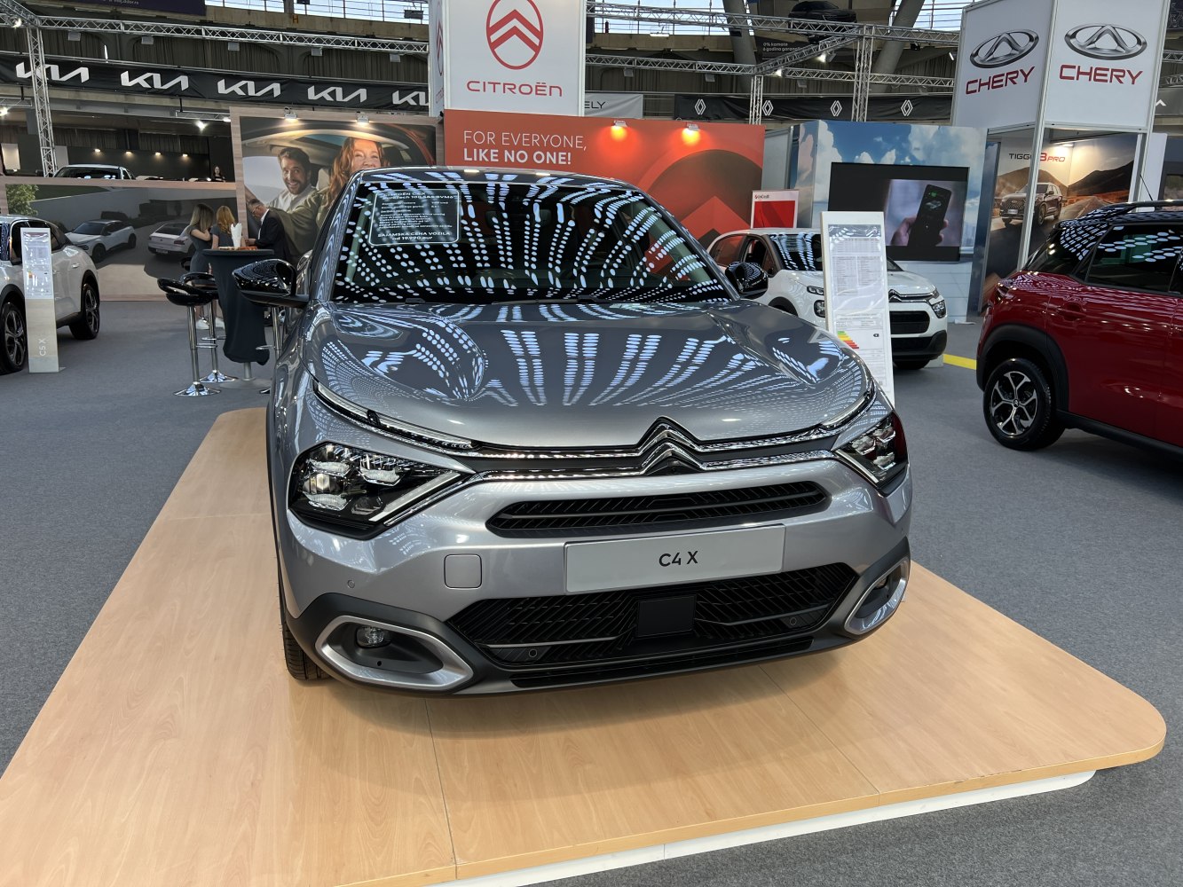 Front view with sharp headlights and sleek grille on display platform