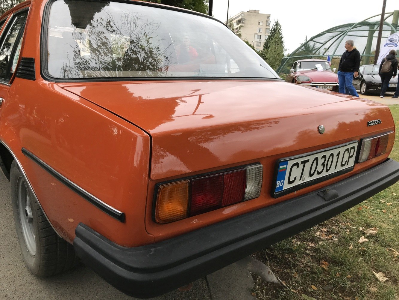 Rear view of orange sedan with classic tail lights and black bumper