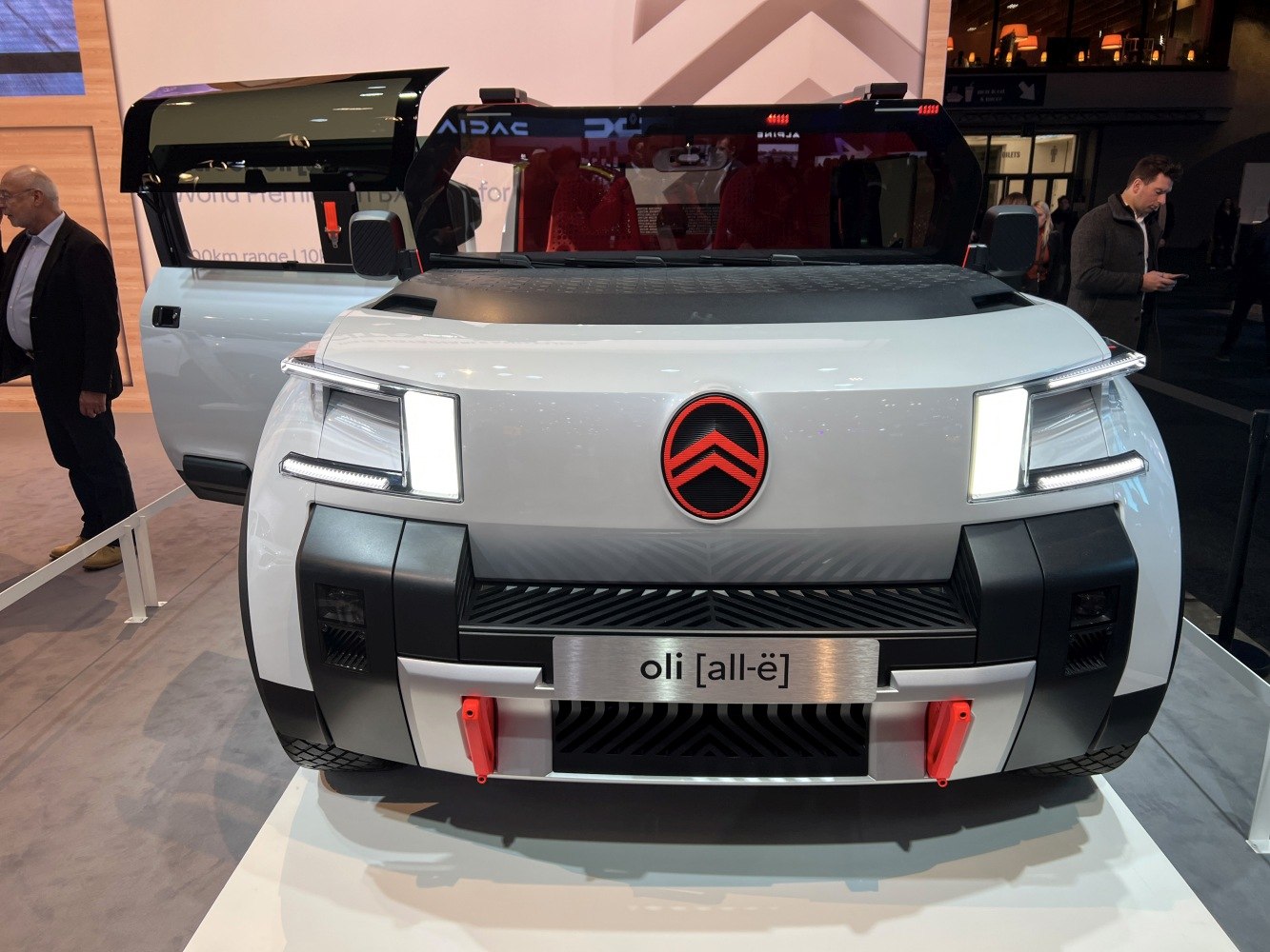 Geometric LED headlights and bold grille on futuristic vehicle front.