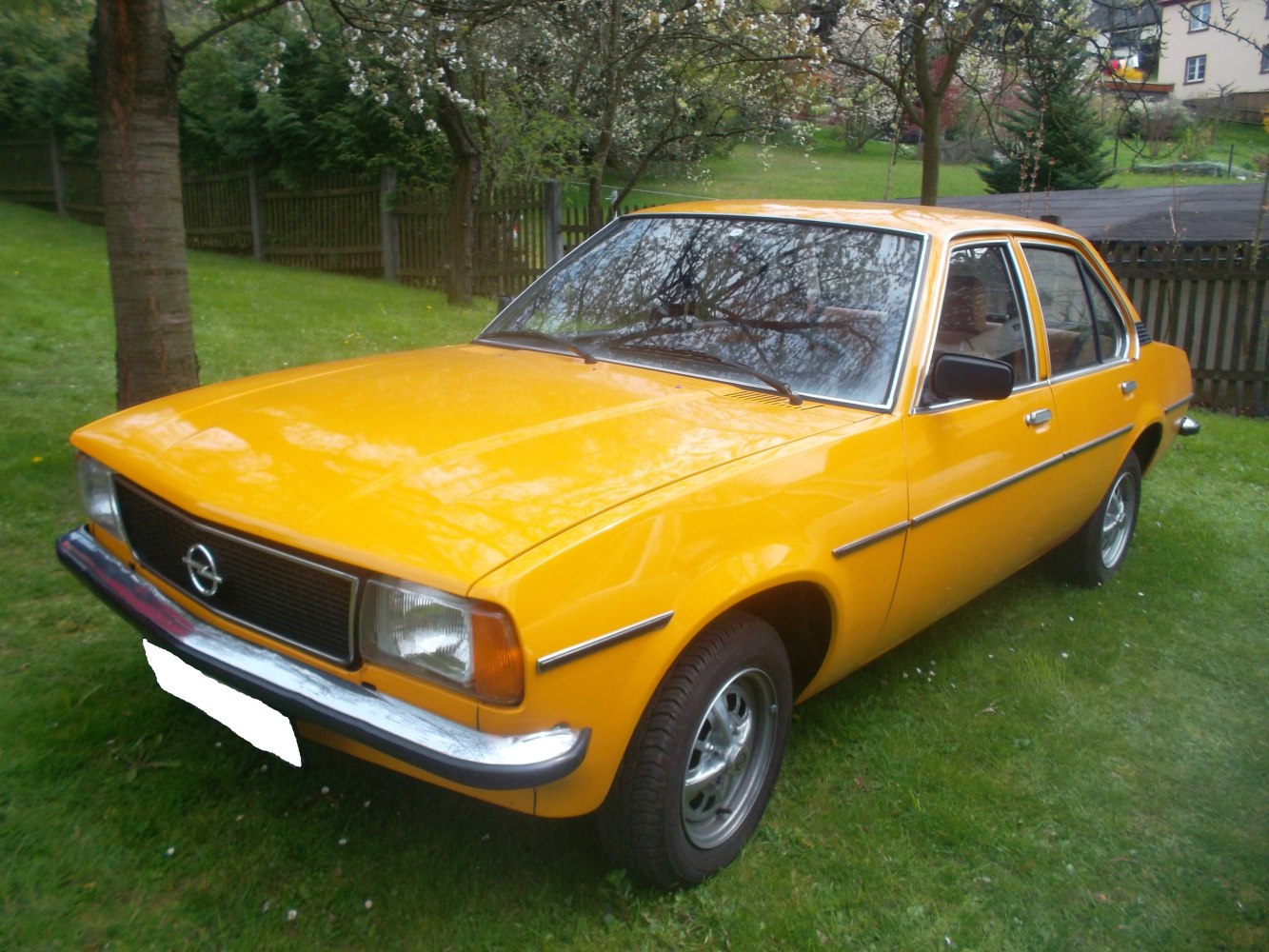 Yellow vintage sedan with classic mid-1970s styling, front side view