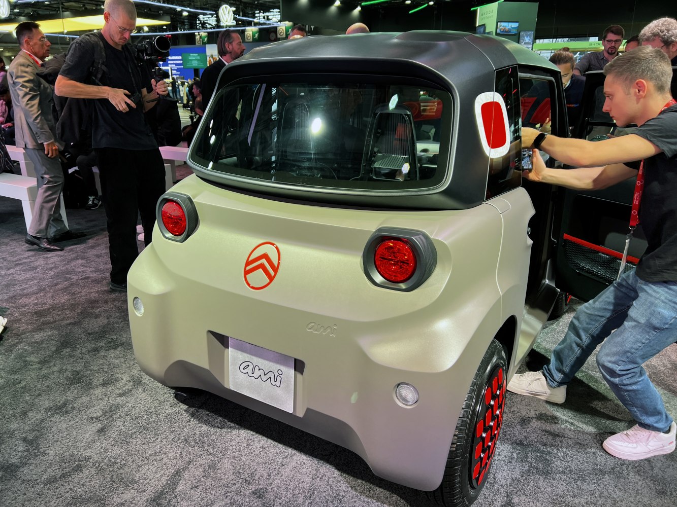 Compact electric microcar rear with round tail lights and two-tone roof design