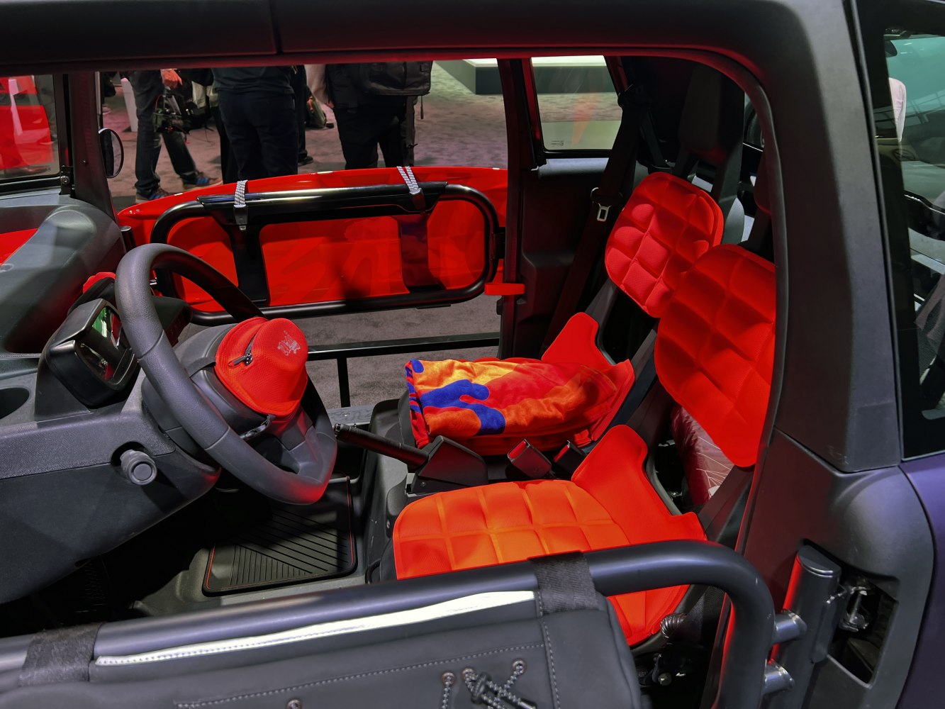 Compact electric buggy interior with bright red seats and open doors