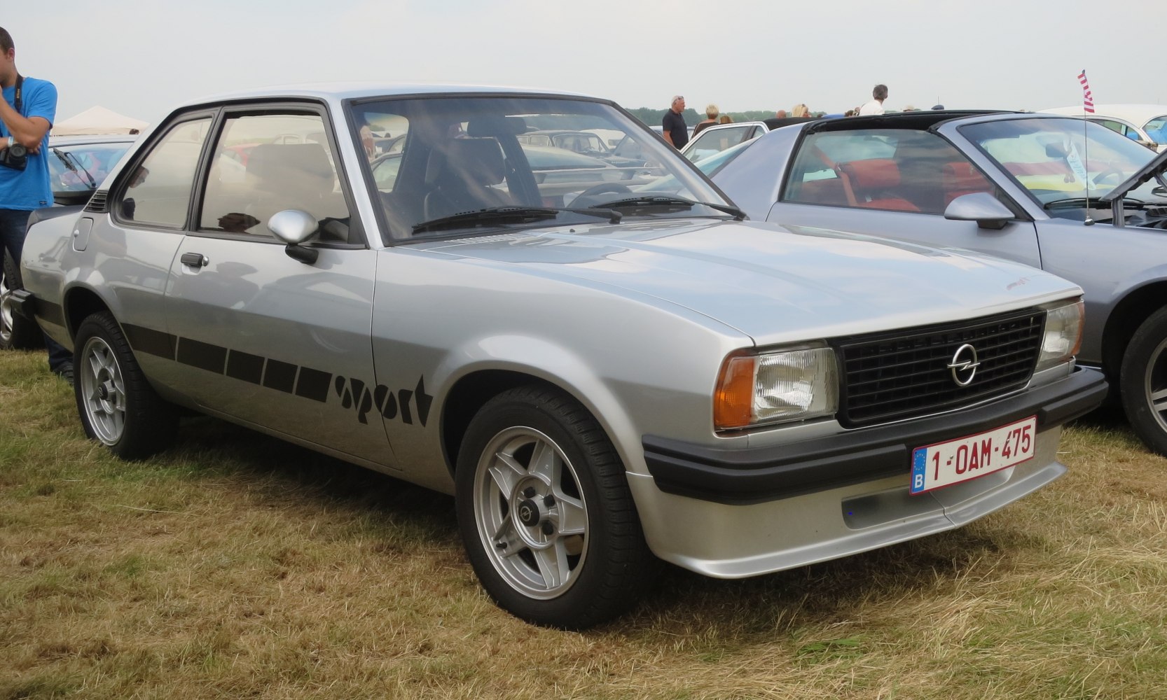 Silver two-door coupe with sport side stripes and alloy wheels