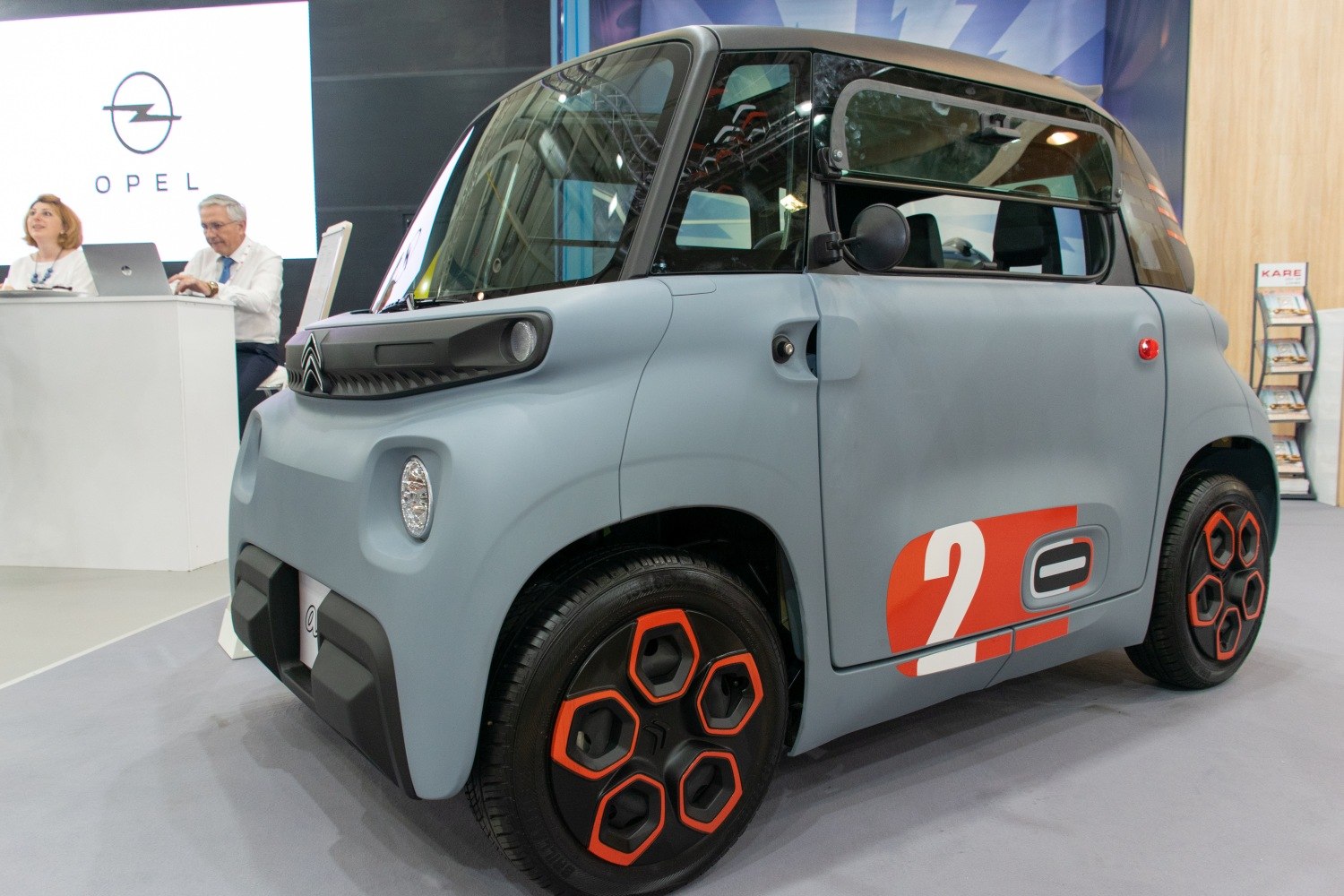 Ultra-compact electric urban vehicle with hexagonal wheel design and innovative door mechanism.