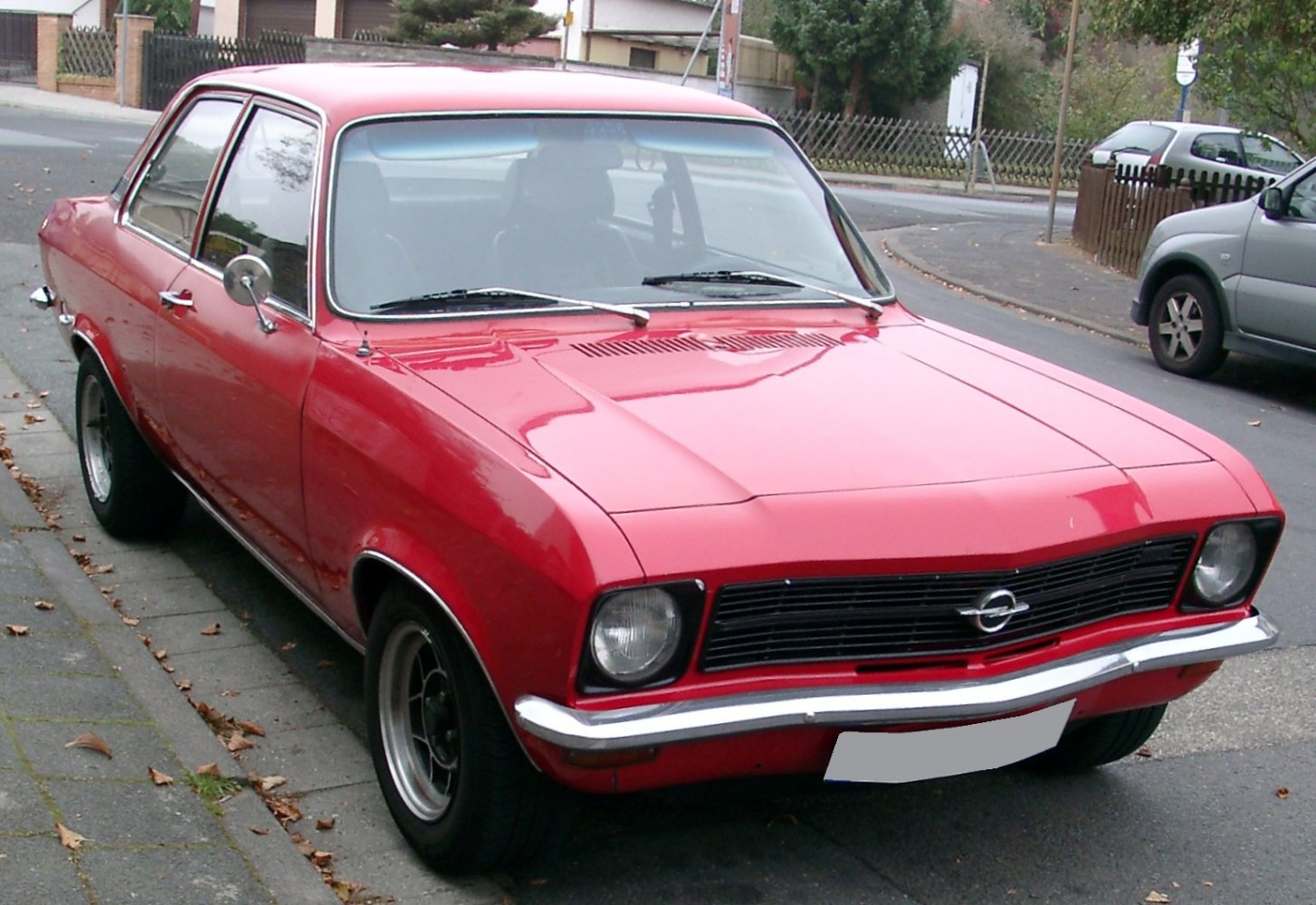 Red 1970s sedan with black grille and chrome bumper