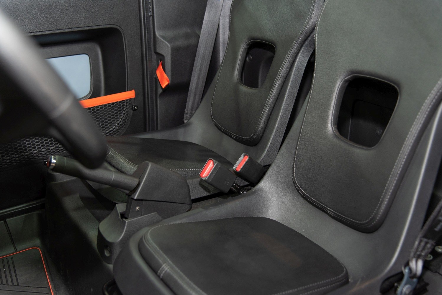 Interior seats and handbrake with seatbelt buckles in compact car cabin