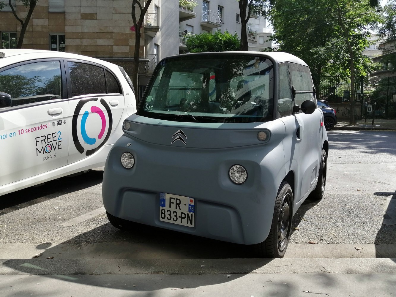Compact electric vehicle with rounded headlights and minimalist front design.