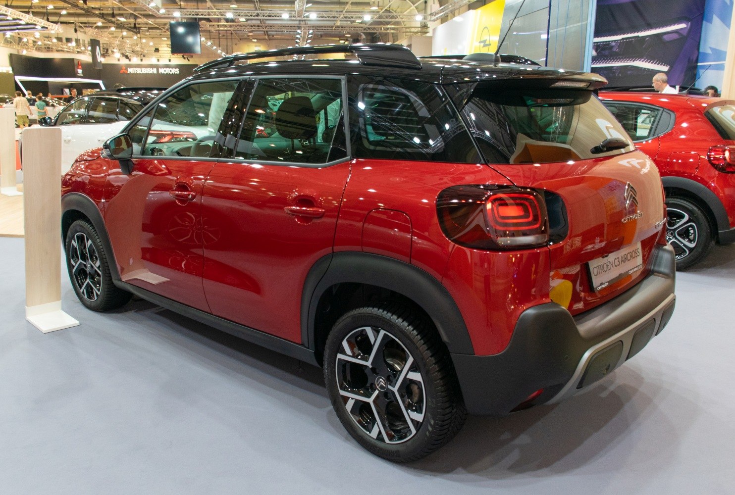Red compact SUV rear and side with distinctive tail lights and black roof