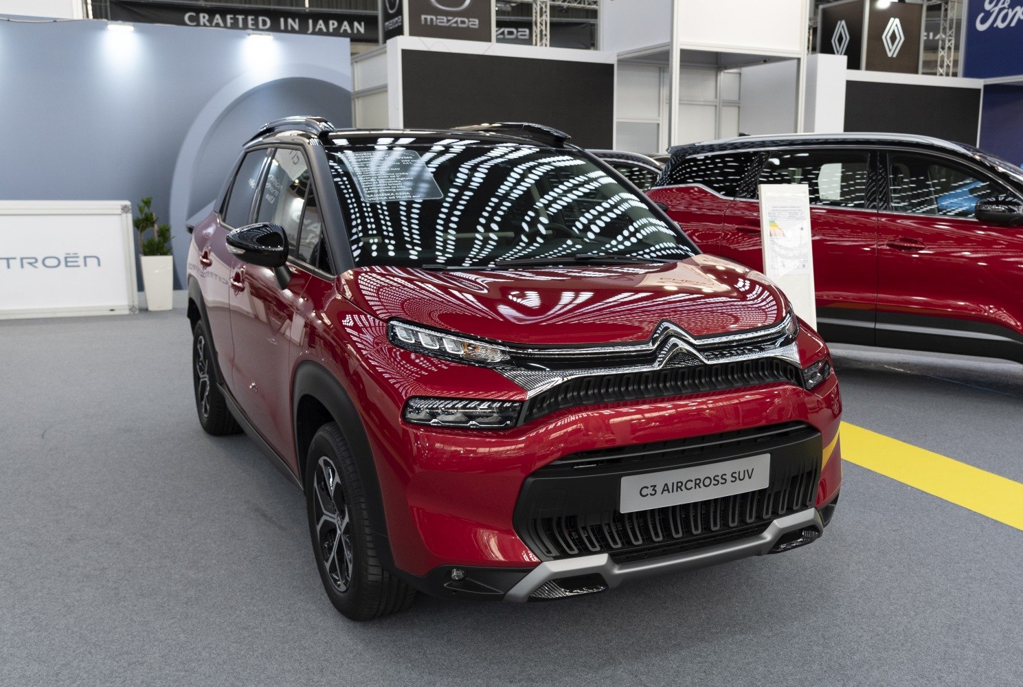 Front view of red compact SUV with dual LED headlights and black grille