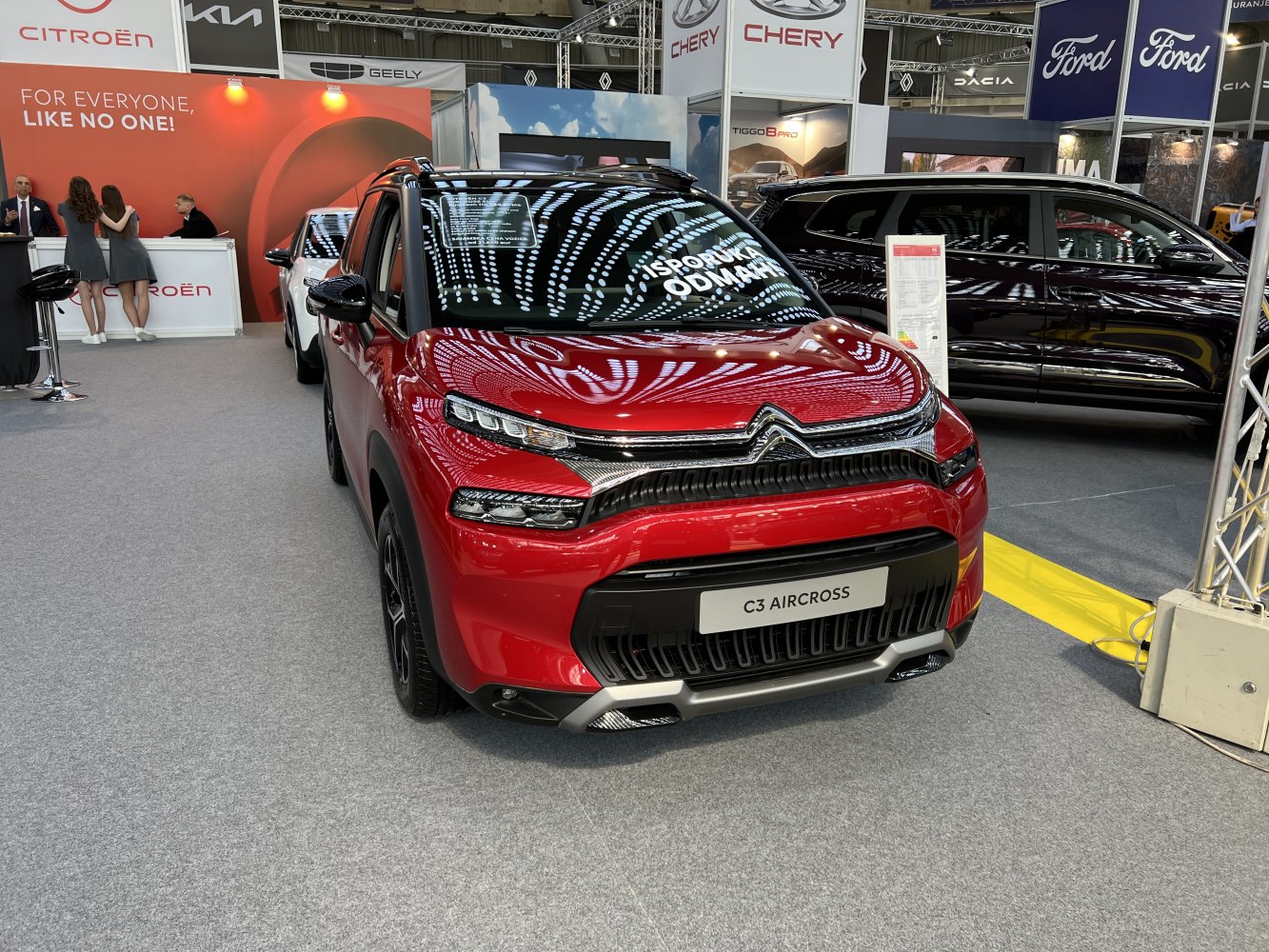 Red compact SUV with LED lights and black mesh grille front view
