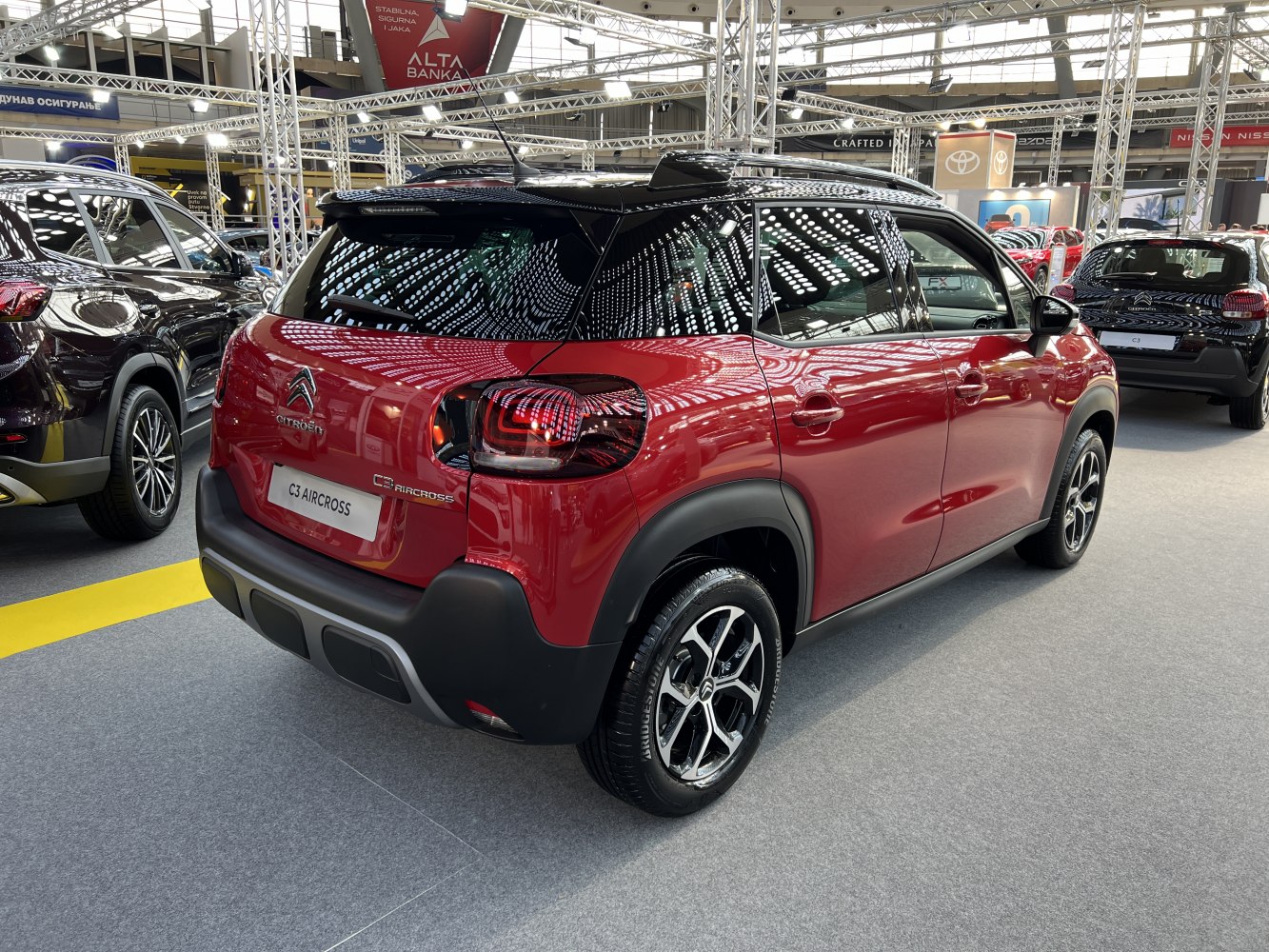 Rear and side view of red compact SUV with black roof and modern taillights